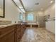 Elegant bathroom with double vanities, a soaking tub, a glass-enclosed shower, and tile flooring at 2444 Grandfather Mtn, Spring Hill, FL 34606