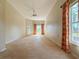 Spacious bedroom featuring a ceiling fan, neutral carpet, and natural light from the window and door at 2444 Grandfather Mtn, Spring Hill, FL 34606