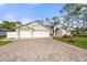 Charming single-story home featuring a brick driveway, three-car garage and lush landscaping at 2444 Grandfather Mtn, Spring Hill, FL 34606