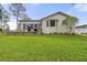 Rear exterior view showcasing the sunroom, patio, and manicured lawn at 2444 Grandfather Mtn, Spring Hill, FL 34606