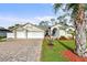 Single-story home featuring a brick driveway, well-maintained lawn, and a welcoming facade at 2444 Grandfather Mtn, Spring Hill, FL 34606