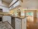 An open kitchen with white cabinets and a granite countertop overlooks the spacious living area at 2444 Grandfather Mtn, Spring Hill, FL 34606