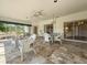 Enclosed sunroom with white wicker furniture, tile flooring, and views of the landscaped yard at 2444 Grandfather Mtn, Spring Hill, FL 34606