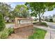 Green Meadow Village brick community sign amid lush greenery, creating a welcoming entrance at 2444 Grandfather Mtn, Spring Hill, FL 34606