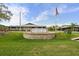 Exterior of Timber Pines Wellness Center features a manicured lawn, sign, and American flag against a blue sky at 2444 Grandfather Mtn, Spring Hill, FL 34606