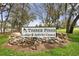 Entrance sign to Timber Pines Lodge & Activity Center, set amidst a stone base and mature trees at 2444 Grandfather Mtn, Spring Hill, FL 34606