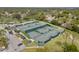 Aerial view of community tennis courts surrounded by lush greenery and convenient parking at 2444 Grandfather Mtn, Spring Hill, FL 34606