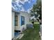 Side view of home featuring neutral siding, blue shutters, A/C unit and well-maintained lawn at 34315 Timberland Blvd, Wesley Chapel, FL 33543