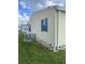 Side view of home featuring neutral siding, blue shutters and a well maintained lawn at 34315 Timberland Blvd, Wesley Chapel, FL 33543
