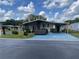 Charming single-story home featuring a covered carport and a screened-in porch, set amidst lush landscaping at 34315 Timberland Blvd, Wesley Chapel, FL 33543