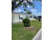 A cozy single-story home with a well-maintained lawn, complemented by bright blue window shutters and awning at 34315 Timberland Blvd, Wesley Chapel, FL 33543