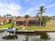 Aerial view featuring a waterfront home with dock, boat lift, screened lanai, and tropical landscaping at 3629 Licata Ct, Punta Gorda, FL 33950