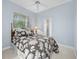 Comfortable bedroom featuring a queen bed, soft natural light, and a view to the bathroom at 3629 Licata Ct, Punta Gorda, FL 33950
