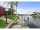 Waterfront home featuring a private dock with channel views and tropical landscaping under a bright blue sky at 3629 Licata Ct, Punta Gorda, FL 33950