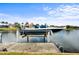 Dock with boat lift offers direct waterfront access to the property under a beautiful blue sky at 3629 Licata Ct, Punta Gorda, FL 33950