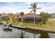 Waterfront home features a private dock, screened lanai, and lush tropical landscaping at 3629 Licata Ct, Punta Gorda, FL 33950