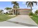 Lovely home with a paver driveway, lush landscaping, and a two-car garage at 3629 Licata Ct, Punta Gorda, FL 33950