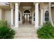 Elegant front entrance with stately columns, double doors, and beautiful landscaping at 3629 Licata Ct, Punta Gorda, FL 33950