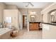 Main bathroom featuring a soaking tub, tiled floors and a wooden vanity at 3629 Licata Ct, Punta Gorda, FL 33950