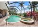 A screened-in lanai features a pool, spa, and waterfront views, providing a luxurious outdoor living experience at 3629 Licata Ct, Punta Gorda, FL 33950