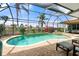 A screened-in lanai features a pool, spa, brick pavers, waterfront views, and comfortable seating for outdoor enjoyment at 3629 Licata Ct, Punta Gorda, FL 33950