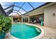 A screened-in lanai with a pool and spa is surrounded by brick pavers and lush landscaping, creating a private retreat at 3629 Licata Ct, Punta Gorda, FL 33950