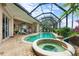 A screened-in lanai with a pool and spa are surrounded by brick pavers and offers the perfect outdoor retreat at 3629 Licata Ct, Punta Gorda, FL 33950