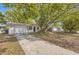 Inviting single-story home with a long driveway and mature landscaping at 3702 Pensdale Dr, New Port Richey, FL 34652