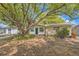 Single-story home with mature landscaping, a dark front door, and a charming front yard at 3702 Pensdale Dr, New Port Richey, FL 34652