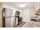Bright kitchen with stainless steel appliances, granite counters, and wood-look floors at 3702 Pensdale Dr, New Port Richey, FL 34652