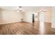 Open-concept living room featuring wood floors and neutral paint, flowing into the kitchen at 3702 Pensdale Dr, New Port Richey, FL 34652