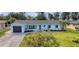 Charming single-story home with manicured lawn, mature trees, and a welcoming front entrance at 23 Golfview Rd, Rotonda West, FL 33947