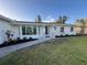 Inviting home exterior with manicured lawn, tasteful landscaping, and a charming walkway leading to the entrance at 23 Golfview Rd, Rotonda West, FL 33947
