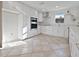 Modern kitchen featuring white cabinets, stainless steel appliances, and neutral tile floors at 23 Golfview Rd, Rotonda West, FL 33947