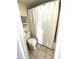 Cozy bathroom with a toilet, towel rack, and tub shower enclosed by a white shower curtain at 3211 W Swann Ave # 408, Tampa, FL 33609