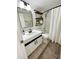 Bathroom with a modern sink, dark fixtures, a decorative shelf, and shower-tub combo at 3211 W Swann Ave # 408, Tampa, FL 33609