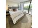 Well-lit bedroom with a queen bed, a private balcony with sliding glass door, and wood floors at 3211 W Swann Ave # 408, Tampa, FL 33609