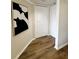Hallway with wood flooring, modern art, and white doors leading to other rooms at 3211 W Swann Ave # 408, Tampa, FL 33609