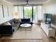Inviting living room with stylish furniture, a neutral rug, and a sliding glass door to a balcony with a view at 3211 W Swann Ave # 408, Tampa, FL 33609