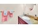 Bathroom with a cherry wood vanity, a marble countertop, and a round mirror at 1111 N Bayshore Blvd # D6, Clearwater, FL 33759