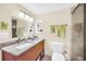 Well-lit bathroom with wood cabinetry, a marble countertop, and a glass-enclosed shower at 1111 N Bayshore Blvd # D6, Clearwater, FL 33759