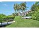 Exterior view of the condos with lush green grass and mature trees by the water at 1111 N Bayshore Blvd # D6, Clearwater, FL 33759