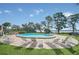 Inviting community pool surrounded by lounge chairs and lush landscaping with a view of the water at 1111 N Bayshore Blvd # D6, Clearwater, FL 33759