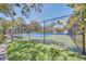Fenced tennis court surrounded by lush greenery, offering a private recreational space at 1111 N Bayshore Blvd # D6, Clearwater, FL 33759