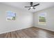 An airy bedroom features two windows with blinds, a ceiling fan, and light-colored vinyl flooring at 3400 Dawson Ln, Punta Gorda, FL 33950
