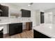Modern kitchen featuring sleek black cabinets, white countertops, and stylish backsplash, next to the entry door at 3400 Dawson Ln, Punta Gorda, FL 33950