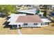 Aerial view of charming home featuring neutral paint, brown roof, Florida room and well manicured landscaping at 520 Baywood S Dr, Dunedin, FL 34698