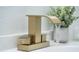 Bathroom sink faucet with waterfall feature complemented by modern accents and decorative plant at 520 Baywood S Dr, Dunedin, FL 34698