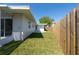 View of the rear of the home with a well maintained lawn and fencing at 520 Baywood S Dr, Dunedin, FL 34698