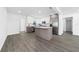 Modern kitchen features white cabinets, grey island, stainless steel appliances, and wood-look floors at 520 Baywood S Dr, Dunedin, FL 34698
